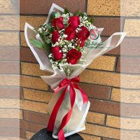 دسته گل رز قرمز با کاغذ سفید